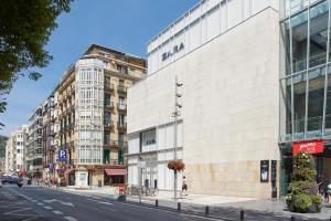 ein großes weißes Gebäude an einer Stadtstraße in der Unterkunft Udare - Basque Stay in San Sebastián