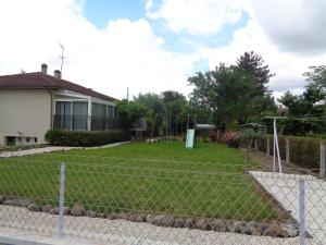 una valla frente a un patio con parque infantil en 5 Cité Creve Coeur, en Manciet