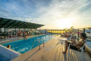 a group of people sitting around a pool on a cruise ship at Onederz Siem Reap in Siem Reap