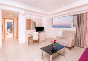 a living room with a desk and a chair at Grand Blue Beach Hotel in Kardamaina