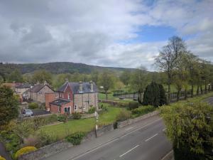 a street with houses and a hill in the distance at Avenue House in Bakewell
