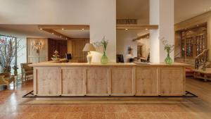 a lobby with a counter with green vases on it at Hotel Excelsior Munich in Munich