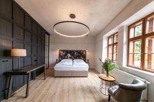 una camera da letto con un letto, una scrivania e finestre di Hotel Clemar a Znojmo