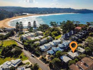 an aerial view of a beach with houses and a orange marker at The Beach Hut Avoca Beach NSW in Avoca Beach