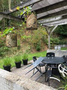 eine Terrasse mit einem Tisch und Stühlen unter einem Holzdach in der Unterkunft Huusje18 in Nunspeet