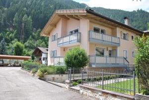 a house with a fence in front of it at B&B 3 Cuori in Predazzo