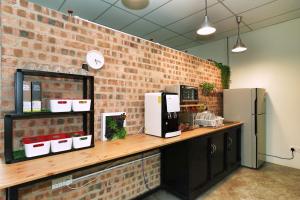 a kitchen with a counter with a brick wall at B@Home in Kluang