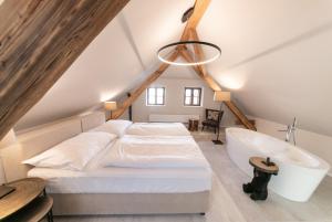 1 dormitorio con 1 cama grande y bañera en Hotel Clemar en Znojmo