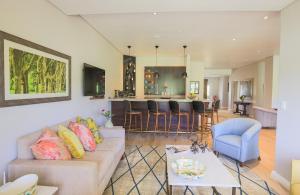 a living room and kitchen with a couch and a table at Mount Edgecombe Estate Lodge in Mount Edgecombe