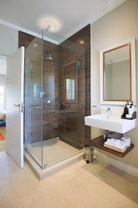uma casa de banho com um chuveiro e um lavatório. em Mount Edgecombe Estate Lodge em Mount Edgecombe