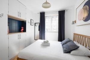 a bedroom with a white bed with a box on it at L'Aurore by Cocoonr in Saint Malo