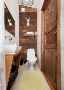 a bathroom with a toilet and a sink and a wooden door at Cute apartment, next to old town, with free parking in Tallinn +10 photos
