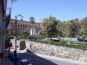 a stone wall next to a street with a building at Casa Normanna in Palermo