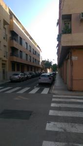 uma rua com carros estacionados ao lado de um edifício em Apartamento San Antonio em Sedaví