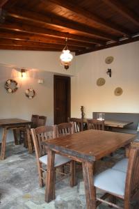Archontiko Klitsa في بورتاريا: غرفة طعام مع طاولات وكراسي خشبية