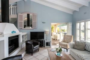a living room with a couch and a fireplace at Dolphin Cottage in Simonʼs Town