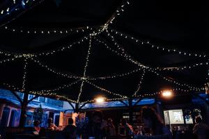 a group of people sitting under a tent with lights at The Ollerod in Beaminster