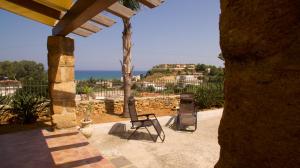 a patio with two chairs and a view of the ocean at Villa Marina Luxury in Balestrate