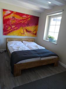 ヴェスターラントにあるART-hüsのベッドルーム1室(ベッド1台付)が備わります。壁には絵画が飾られています。