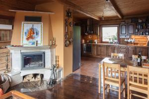 een keuken met een open haard en een tafel met stoelen bij Mountain cabin in Pcim