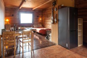 eine Küche und ein Wohnzimmer mit einem Kühlschrank und einem Tisch in der Unterkunft Mountain cabin in Pcim