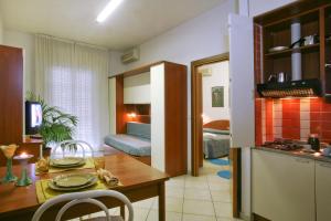 Residence I Girasoli في ريميني: مطبخ وغرفة معيشة مع طاولة وغرفة طعام