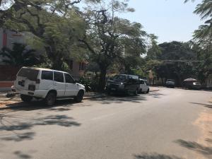 dwa samochody zaparkowane po stronie ulicy w obiekcie Acacia Inn GuestHouse w mieście Maputo