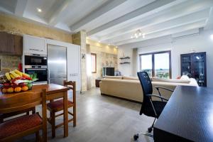 a kitchen and living room with a table and a couch at Iridanos Villa in Kissamos