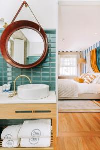 a bathroom with a sink, mirror and bath tub at Gran Cruz House in Porto