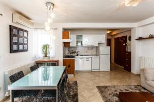 a kitchen and living room with a glass table at Apartments & Rooms Milcetic M in Malinska