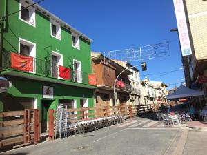 ein grünes Gebäude mit Tischen und Stühlen auf einer Straße in der Unterkunft La Casa del Hilario in Milagro