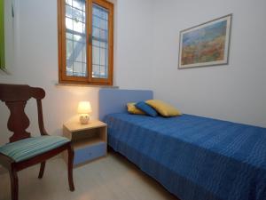 ein Schlafzimmer mit einem Bett, einem Stuhl und einem Fenster in der Unterkunft Villa Sabrina in Lignano Sabbiadoro
