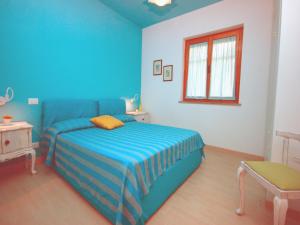 ein blaues Schlafzimmer mit einem Bett und einem Fenster in der Unterkunft Villa Sabrina in Lignano Sabbiadoro