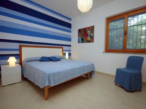 ein Schlafzimmer mit einem Bett und einem blauen Stuhl in der Unterkunft Villa Sabrina in Lignano Sabbiadoro