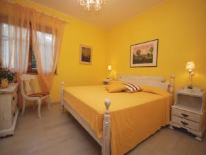ein gelbes Schlafzimmer mit einem Bett und einem Stuhl in der Unterkunft Villa Sabrina in Lignano Sabbiadoro