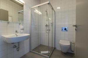 a bathroom with a shower and a sink and a toilet at Air Hotel in Karmėlava