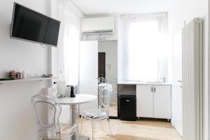 een woonkamer met een tafel en stoelen en een televisie bij Myrtha bb in Bologna