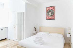 een witte slaapkamer met een bed met handdoeken erop bij Myrtha bb in Bologna