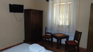 Habitación con mesa, 2 sillas y TV. en Rooms Milin Lagum, en Irig