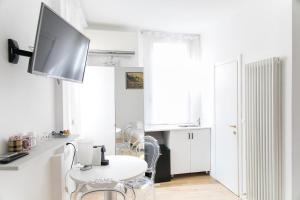 una cucina bianca con tavolo e TV a parete di Myrtha bb a Bologna