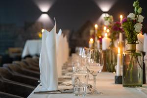 a long table with glasses and flowers and candles at Van der Valk Hotel Hildesheim in Hildesheim