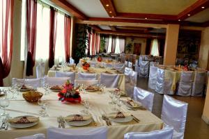 uma sala de jantar com mesas brancas e cadeiras brancas em Hotel Bucolia em Lamezia Terme