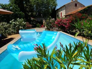 a swimming pool with blue chairs in a yard at Une Parenthese pour Deux in Plan-dʼOrgon