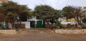 a house with a green door and some trees at Surf House Hostel in Santa Maria