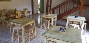 a group of tables and stools in a room at Surf House Hostel in Santa Maria