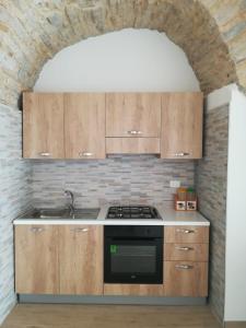 uma cozinha com armários de madeira e um forno com placa de fogão em Belvedere dei monti Dauni di Castelluccio valmaggiore em Castelluccio Valmaggiore