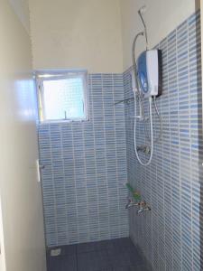 a blue tiled bathroom with a shower and a window at Jacyjoka Apartments Nyali in Mombasa