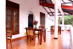 a dining room with wooden tables and chairs at Amal Guest house in Mirissa