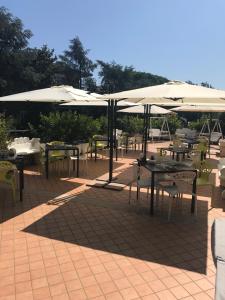 a patio with tables and chairs with umbrellas at Smooth Hotel Rome West in Rome