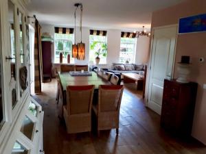 a living room with a table and chairs and a couch at Villa Martensplek met sauna in Tiendeveen